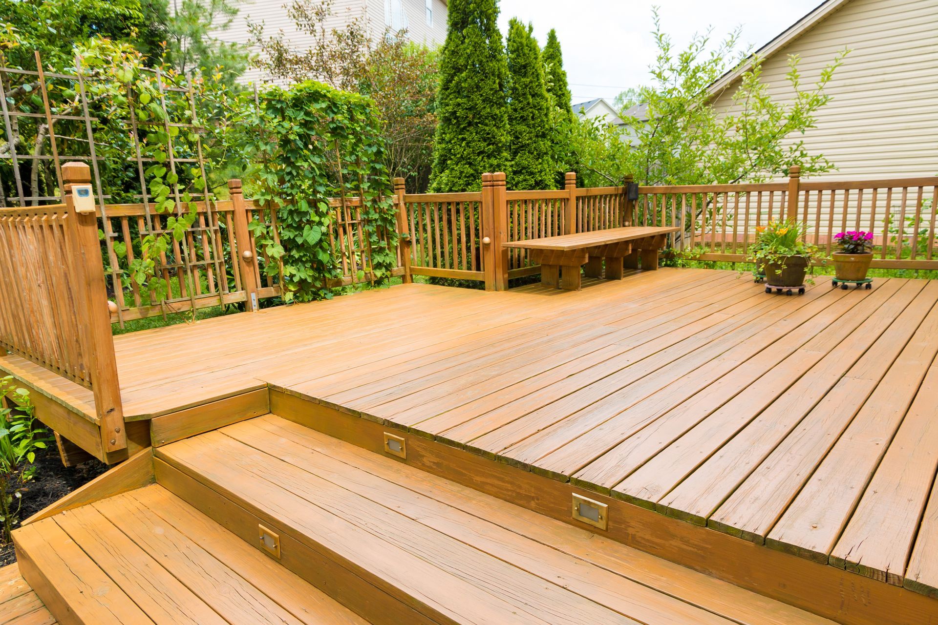 Multi-level stained wood deck with built-in bench seating and railings