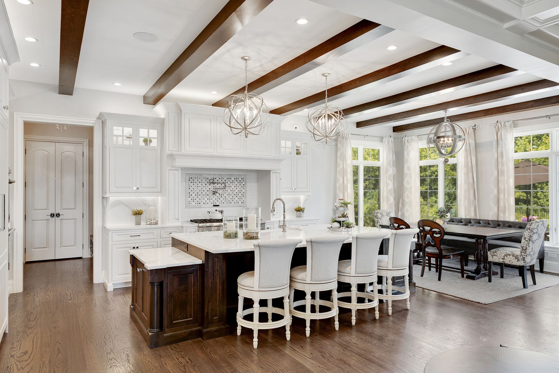 Remodeled kitchen with a large granite island, custom cabinetry and pendant lighting